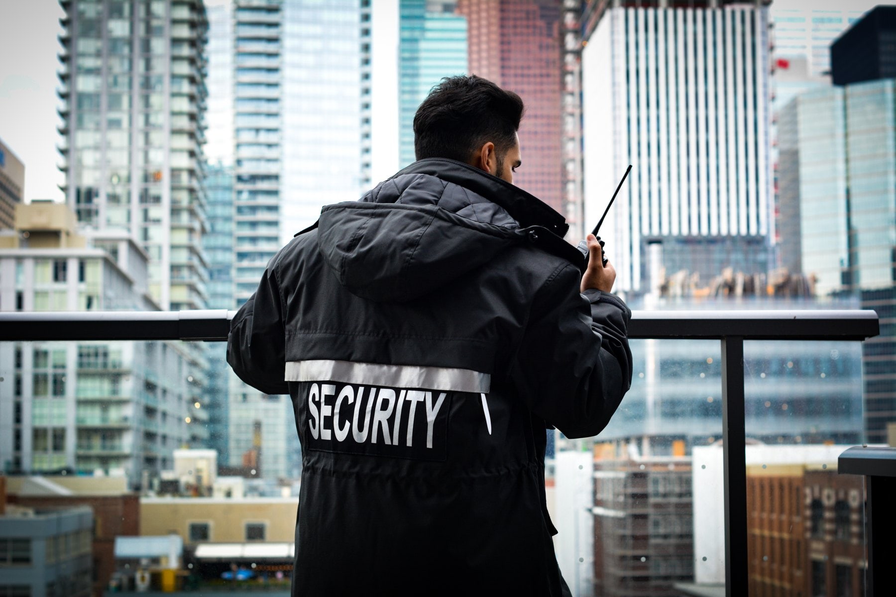 Royal security officer in a SECURITY jacket, Toronto skyline behind